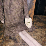 Primitive Doll Holding A Piece Of Fabric That Has ABC,123 Stocked In To It